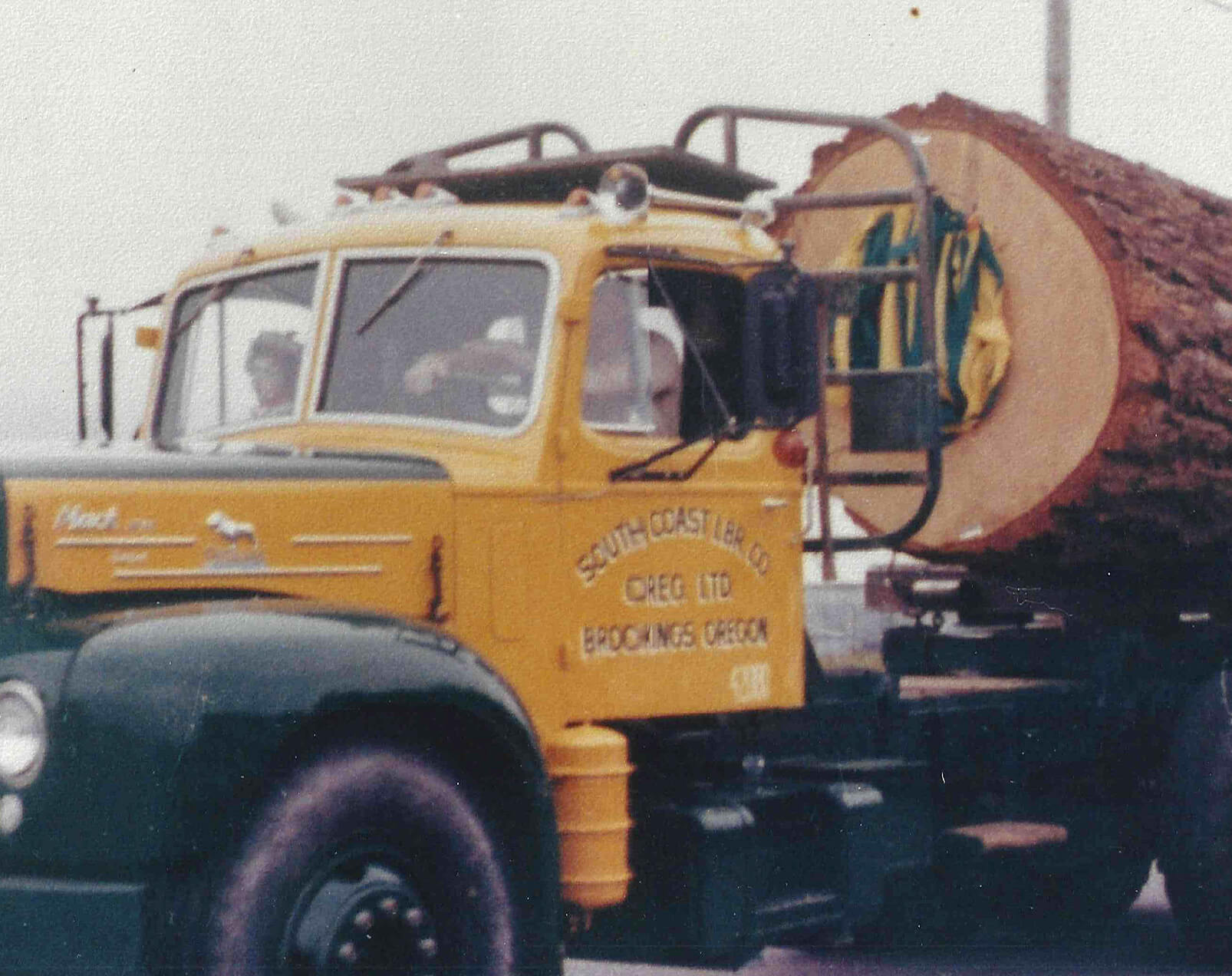 vintage photo of a yellow south coast lumber truck with a large log